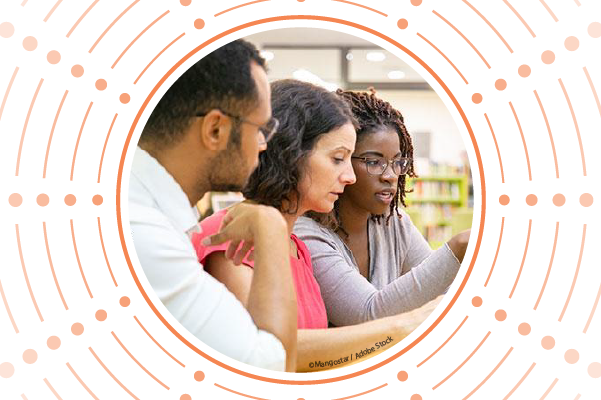 A man and woman are learning new computer skills with a woman teaching them