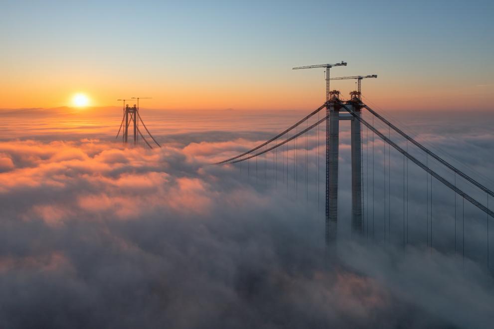 Panoramic aerial drone view from above of the suspended bridge over danube river, under construction, between Braila and Tulcea cities in Romania